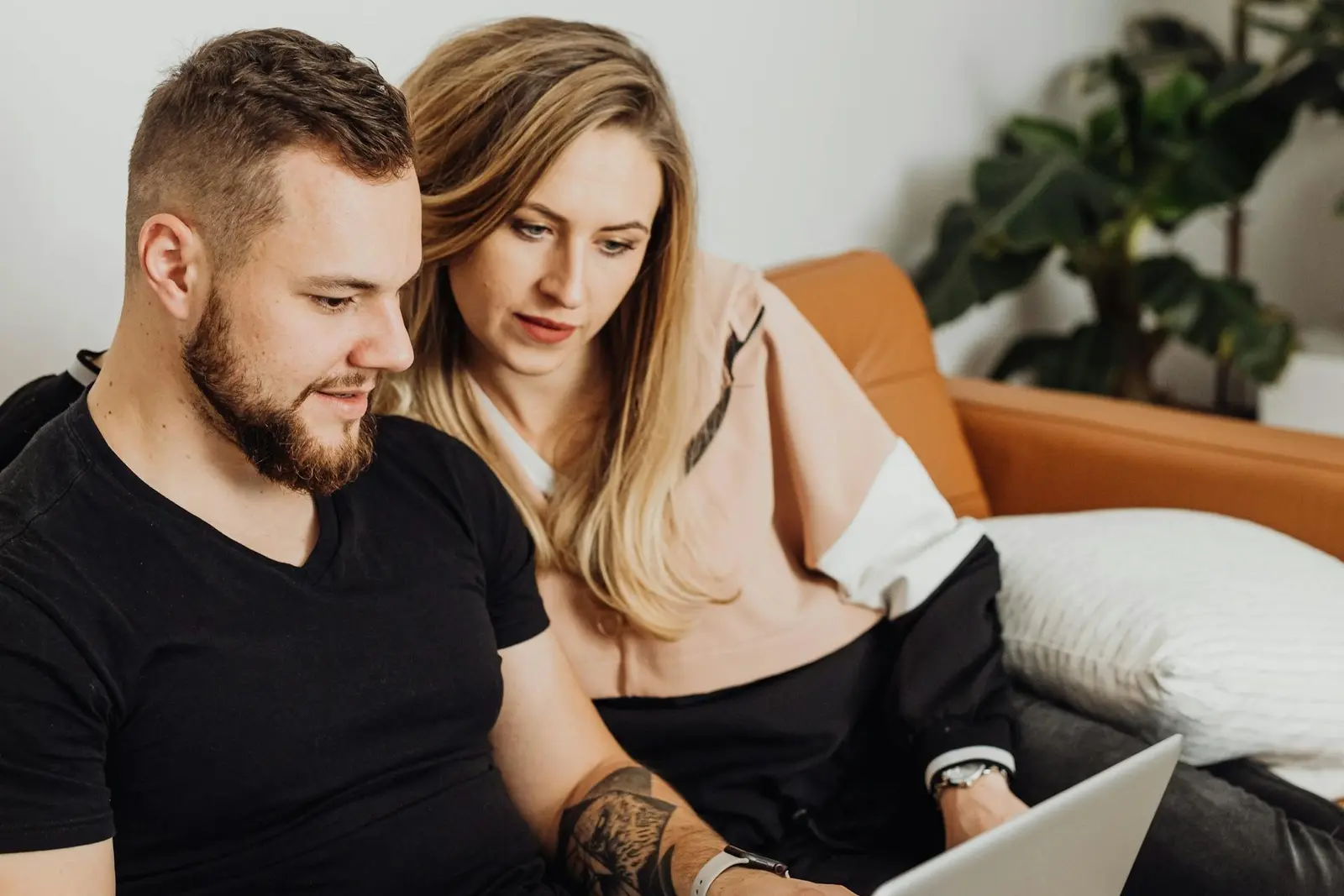 Couple looking carefully at solar power calculations on laptop